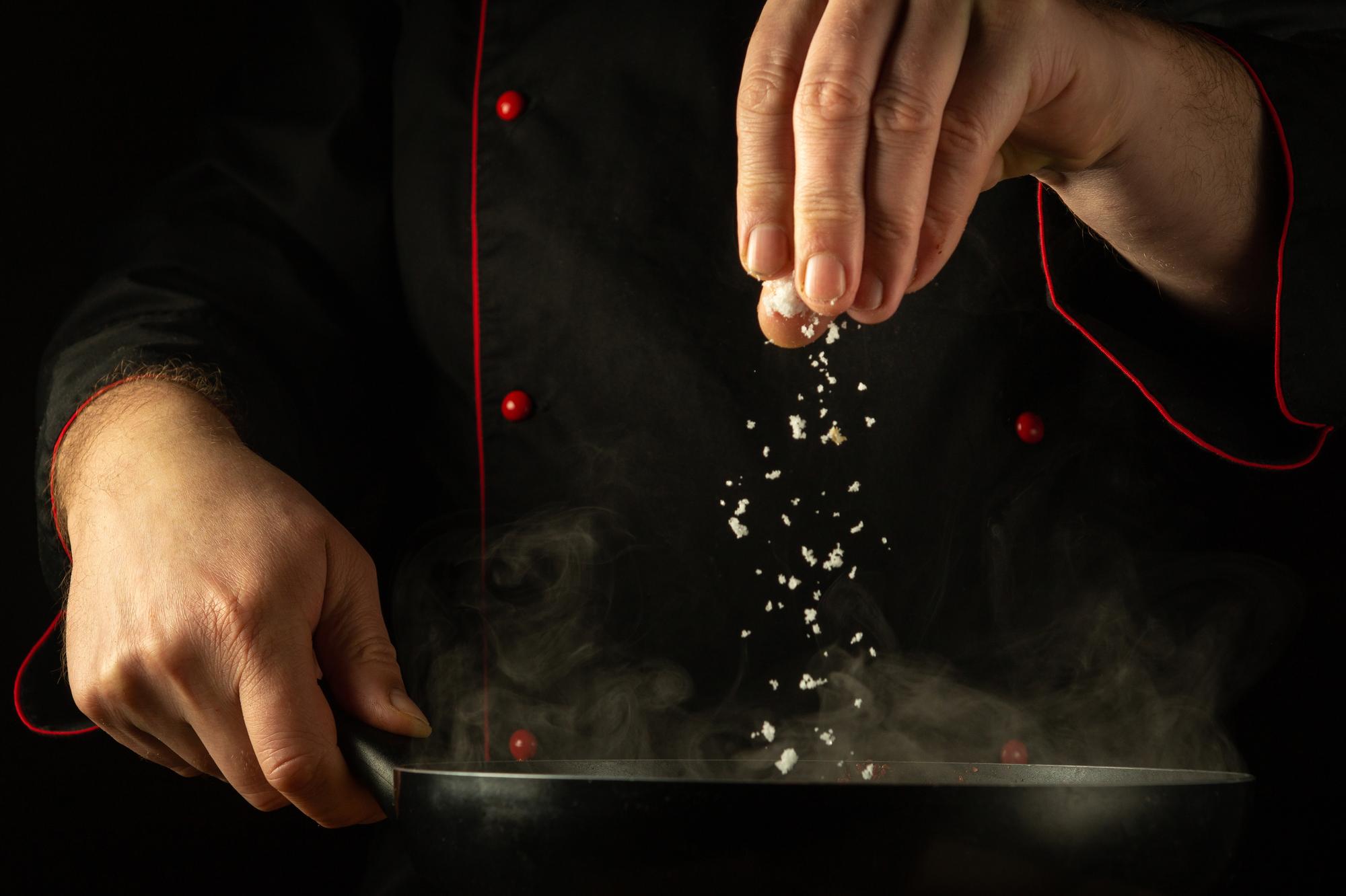 Portrait of chef sprinkling salt